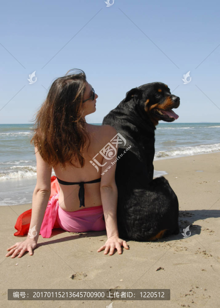 海灘上的女人和她的羅特韋爾犬