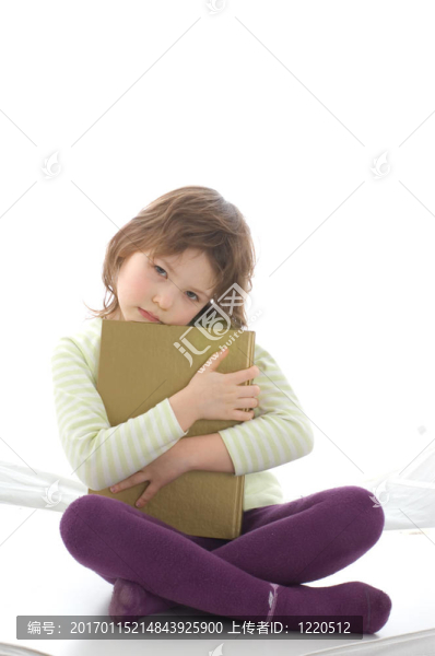 一個(gè)年輕的傷心的女孩拿一本書
