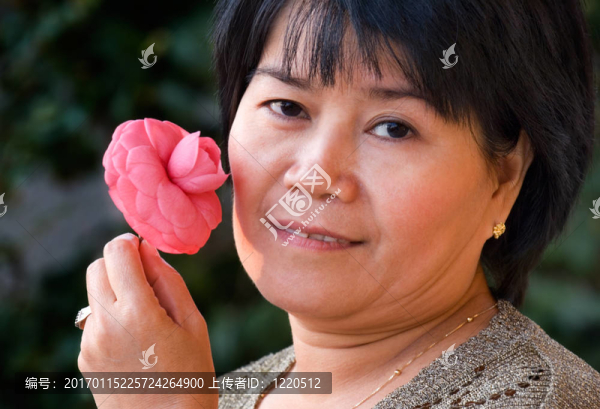 亞洲女人捧著一朵粉紅色的花