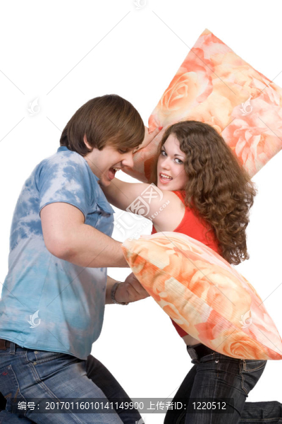這對年輕的夫妻打架枕頭。分離
