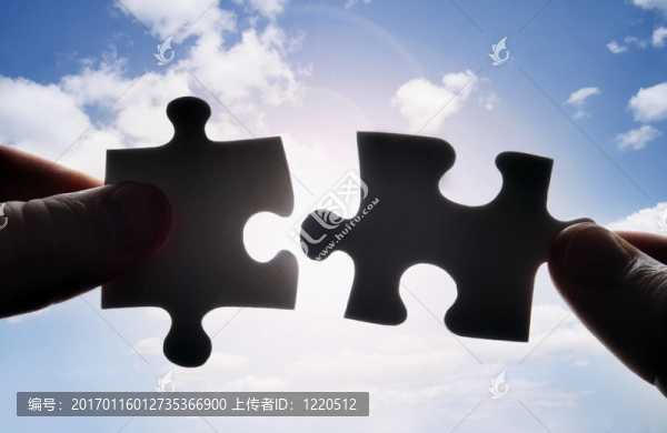 雙手試圖把兩塊拼圖拼在一起