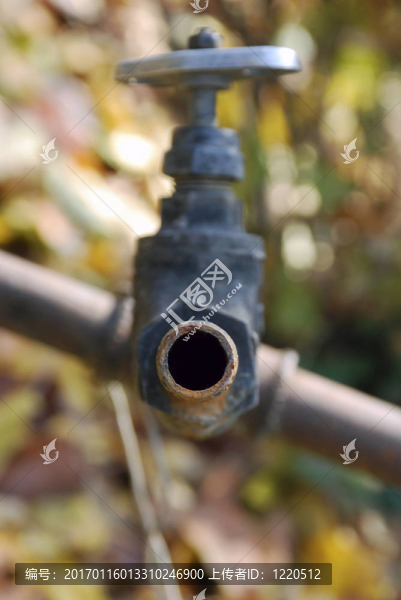 舊的生銹的水龍頭在秋天的背景色