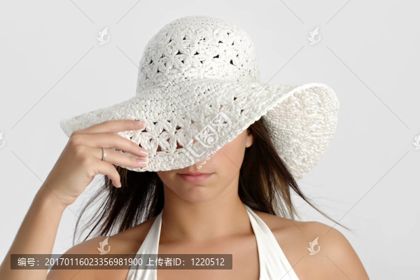年輕的女人拿著一頂帽子