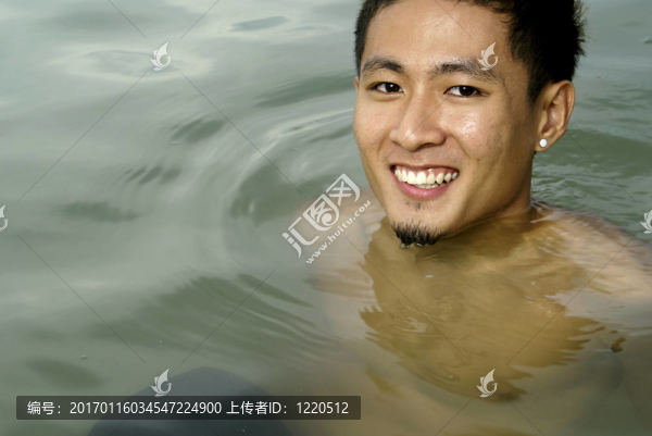 微笑的亞洲男子在海上