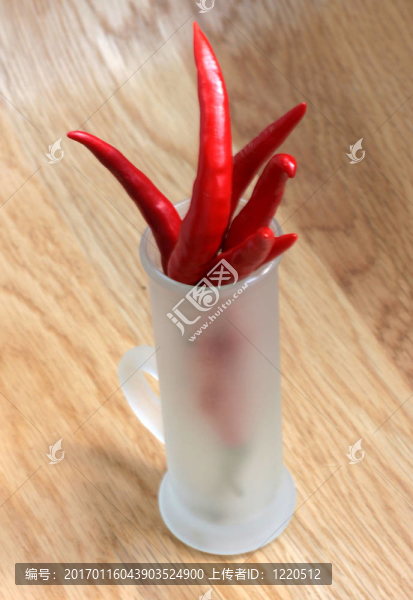 在磨砂玻璃上木桌子的紅辣椒