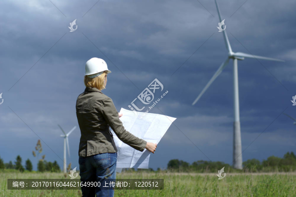 具有白色安全帽和背景風(fēng)機(jī)的女工程師或建筑師