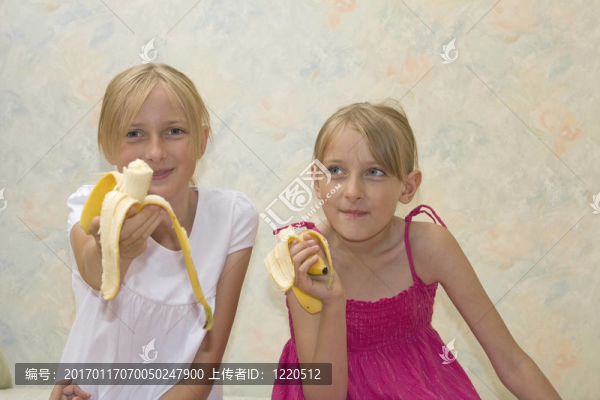 兩個美麗的姐妹吃香蕉
