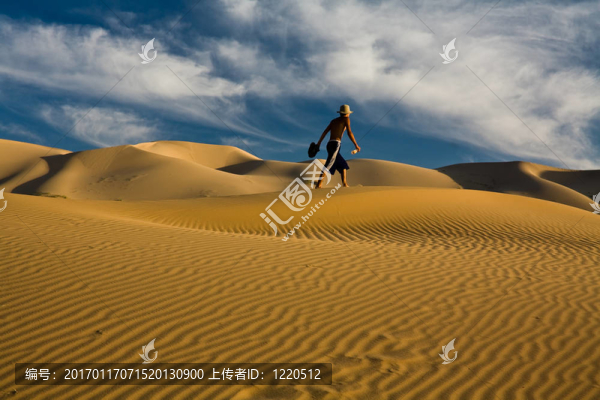 獨(dú)自行走在沙漠沙丘上的男人