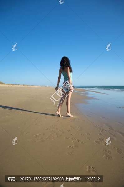 背穿衣服的女人在海灘上
