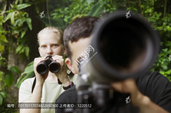漂亮的女人在Jungle用望遠(yuǎn)鏡和望遠(yuǎn)鏡