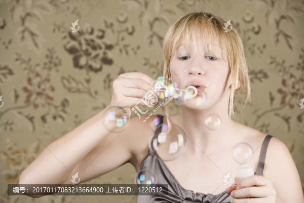 漂亮的年輕女孩吹泡泡