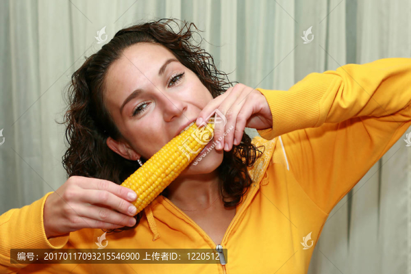 年輕女孩吃玉米