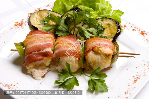 烤的雞肉包裹在培根弦木串飾以烤茄子；在白盤沙拉和香菜葉