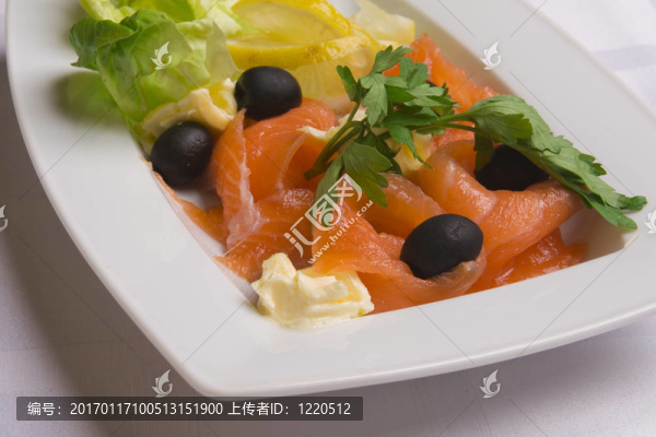 咸鮭魚配沙拉葉；檸檬片；橄欖和歐芹在白盤子上