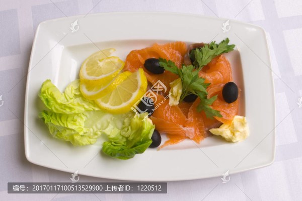 咸鮭魚配沙拉葉；檸檬片；橄欖和歐芹在白盤子上