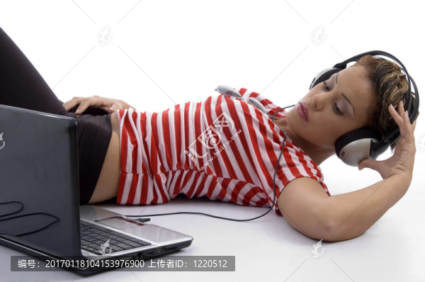 拿著耳機(jī)和看筆記本電腦的女人