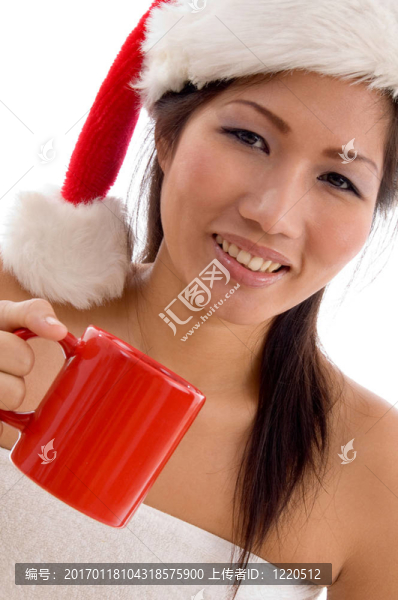 帶圣誕帽的年輕女子拿著咖啡杯