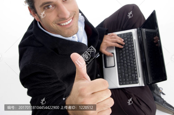 英俊的會計(jì)工作筆記本的手勢豎起大拇指