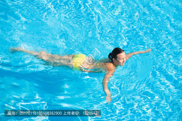美麗的女人在游泳池游泳