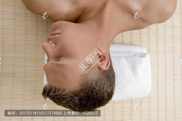 年輕男性躺在墊子上準(zhǔn)備接受SPA治療