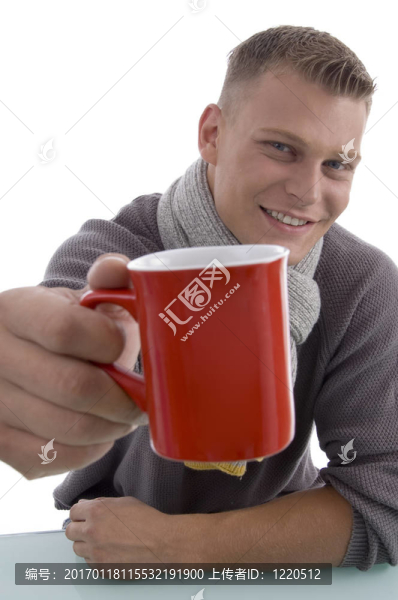 英俊的年輕人展示咖啡杯