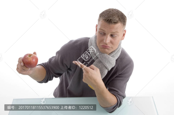 年輕男子指著蘋果-匯圖網(wǎng) www.fosd68.com 年輕男子指著蘋果