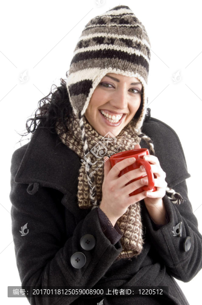 微笑的女人拿著冬天的帽子拿著咖啡杯