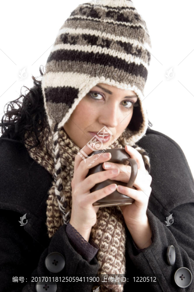 帶著冬天帽的女人拿著咖啡杯