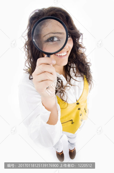 年輕的女孩拿著放大鏡，放大顯示她的眼睛