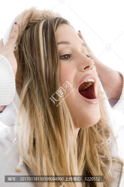 特寫鏡頭的幸福女性持有她的夾克帽在她的頭與白色背景