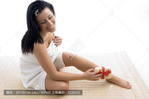 微笑的女人在擦她的腿