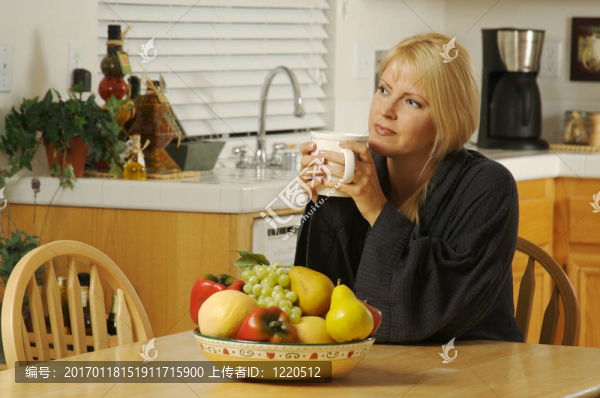 廚房里的女人用一杯咖啡
