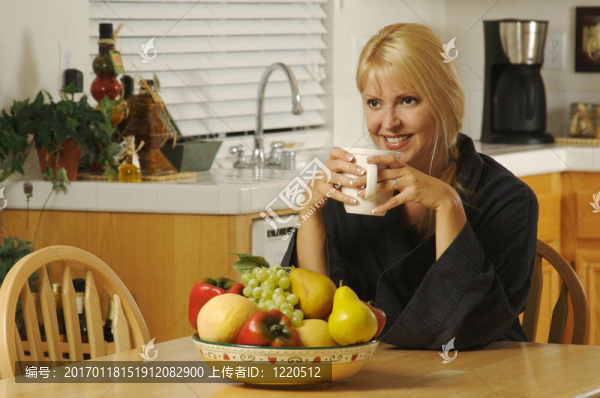 女人帶著咖啡杯在廚房微笑