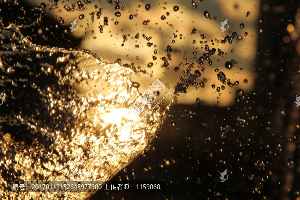 太陽(yáng)光夕陽(yáng)下的噴泉水珠背景