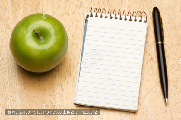 鋼筆；紙和蘋果在木頭上