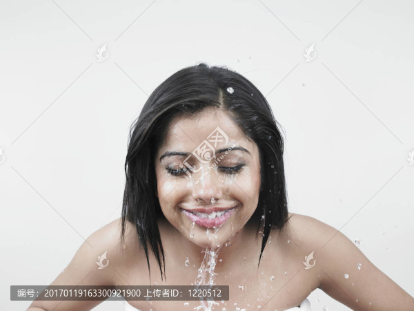 女人用水洗她的臉