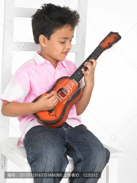 亞洲男孩玩玩具吉他