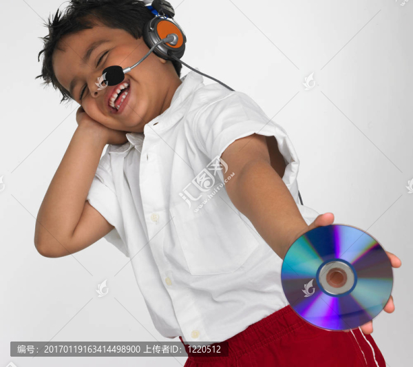 拿著一個(gè)緊湊的光盤(pán)的亞洲男孩
