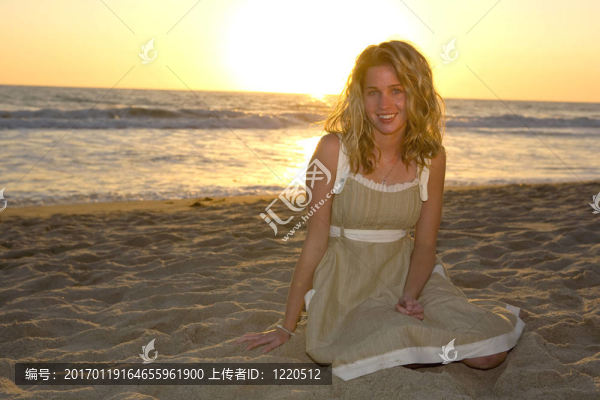 微笑的女孩坐在海灘上-匯圖網(wǎng) www.fosd68.com 微笑的女孩坐在海灘上