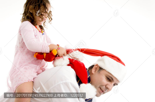 女孩抱著玩具騎在她父親的背上