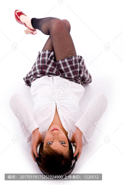 地板上聆聽音樂的女人的高視角