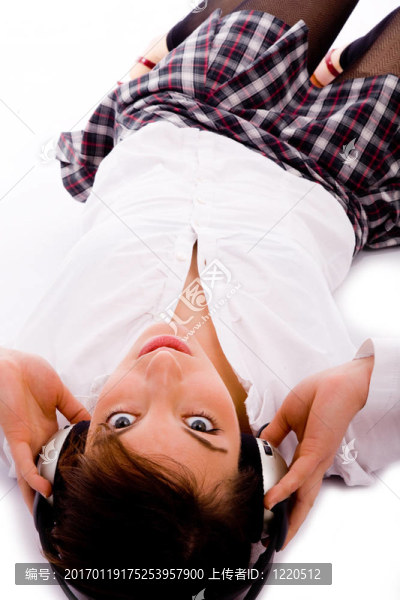 高角度看女人看相機和聽音樂對白色背景
