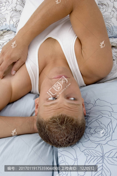累了的年輕男子在床上放松