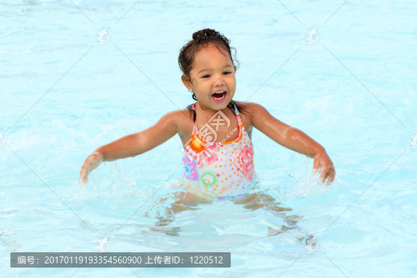 在游泳池里的快樂的小女孩