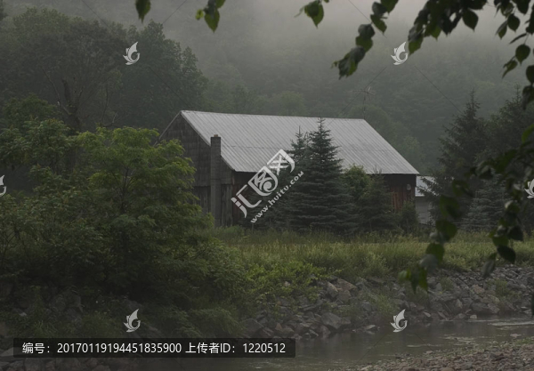 一個古樸的木屋掩映在樹林旁的小溪