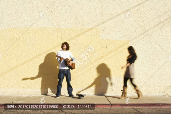 人行道上的音樂家和女行人