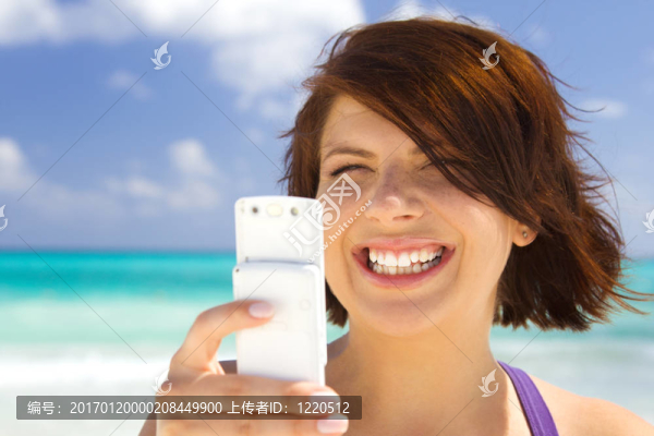 快樂(lè)的女人在海灘上的電話