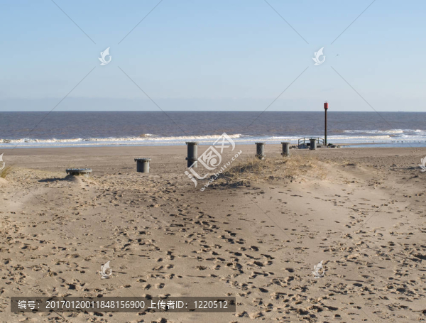 有危險標志的沙灘上的管道