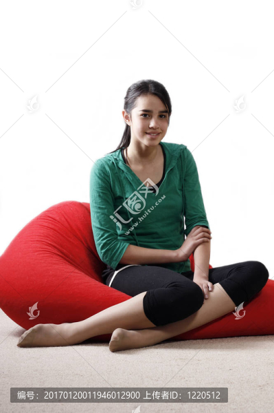 一個年輕的姑娘坐在豆袋