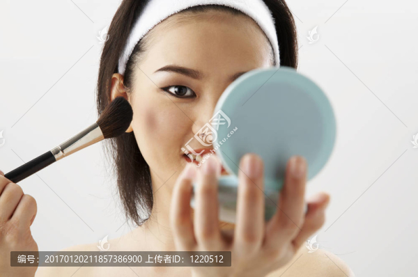 應(yīng)用化妝的年輕女人